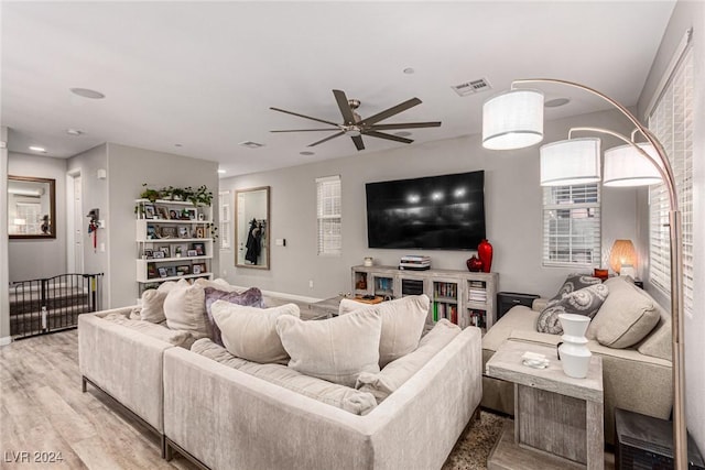 living room with light hardwood / wood-style flooring and ceiling fan