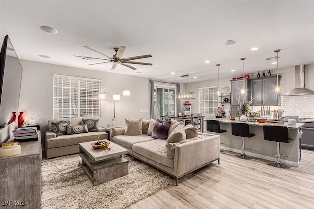 living room with ceiling fan and light wood-type flooring