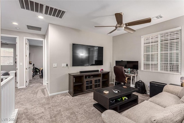 carpeted living room with ceiling fan