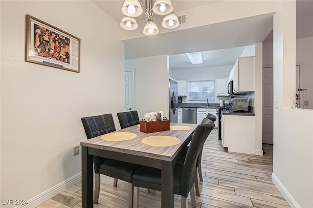 dining space featuring light wood-type flooring and sink