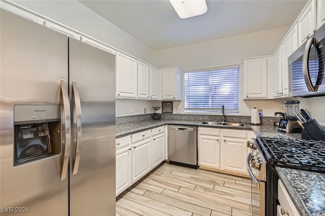 kitchen featuring appliances with stainless steel finishes, white cabinetry, and sink