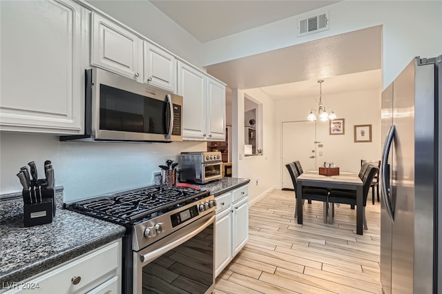 kitchen featuring white cabinets, stainless steel appliances, light hardwood / wood-style floors, and a notable chandelier