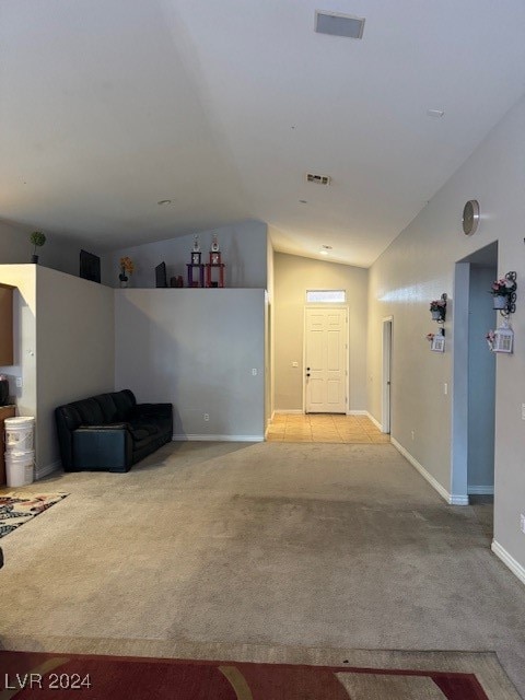 unfurnished living room featuring light carpet and vaulted ceiling