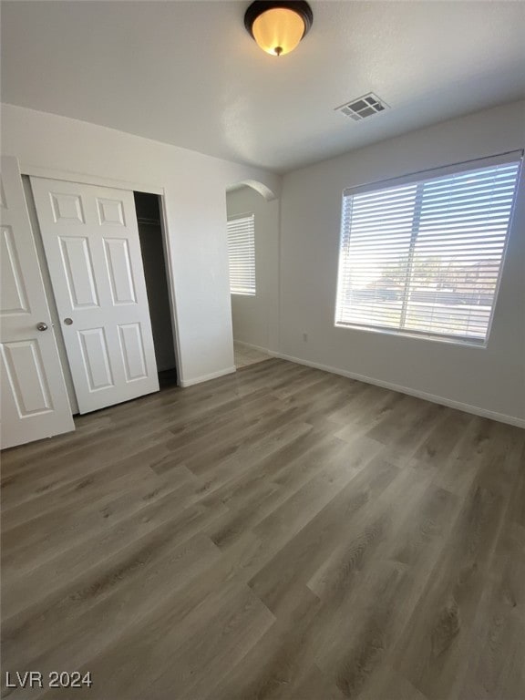 unfurnished bedroom with dark hardwood / wood-style floors and a closet