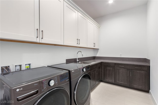 washroom with cabinets, sink, and washing machine and dryer