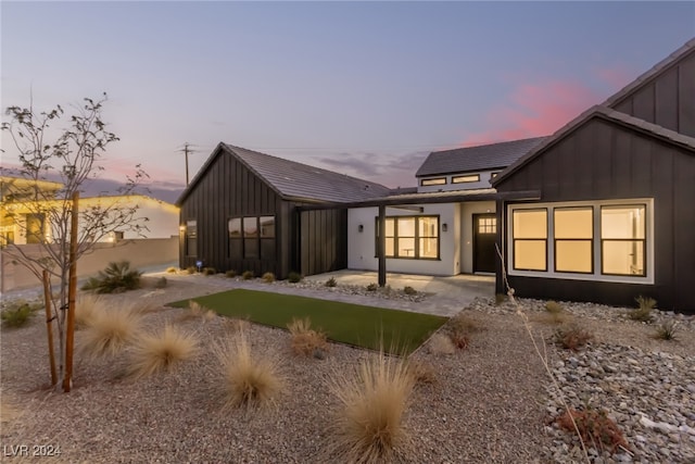 back house at dusk with a patio