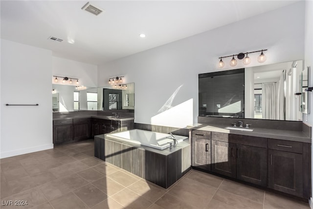 kitchen with kitchen peninsula, dark brown cabinets, tile patterned flooring, and sink