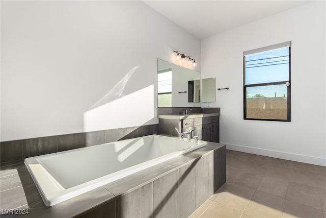 bathroom featuring tile patterned floors, vanity, and a relaxing tiled tub