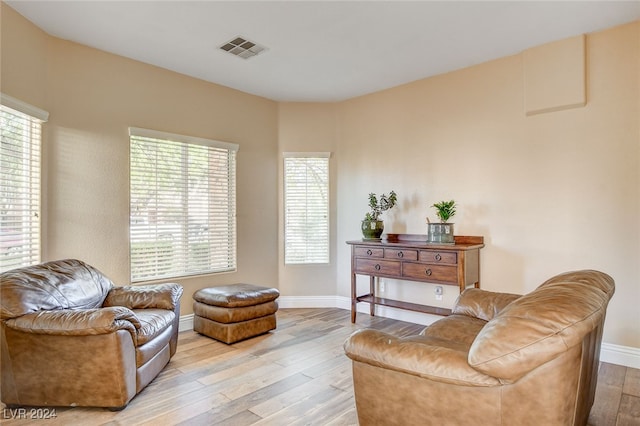 sitting room with visible vents, baseboards, and light wood-style floors