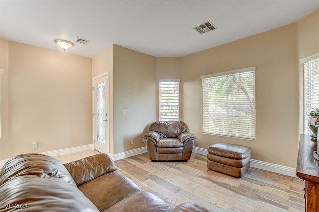 living area with visible vents, baseboards, and wood finished floors