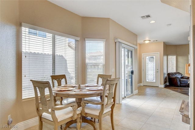 dining space featuring light tile patterned floors, visible vents, and baseboards