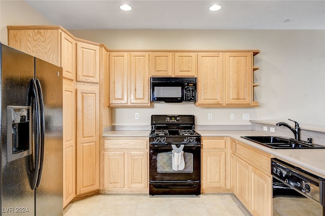 kitchen with black appliances, light brown cabinets, a sink, light tile patterned flooring, and light countertops