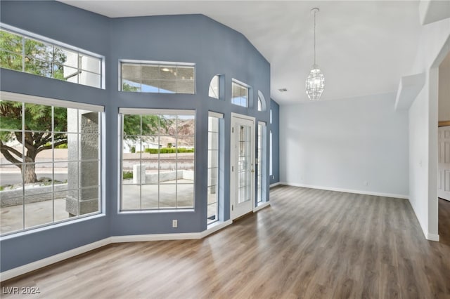 interior space with hardwood / wood-style floors, lofted ceiling, and an inviting chandelier