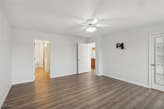 empty room with dark hardwood / wood-style flooring and ceiling fan