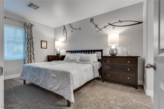 bedroom with baseboards, visible vents, and light colored carpet