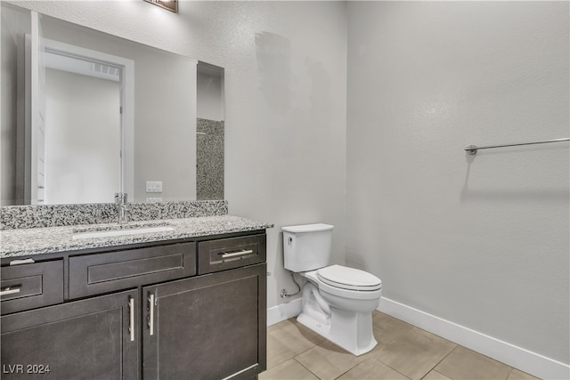 bathroom with tile patterned flooring, vanity, and toilet