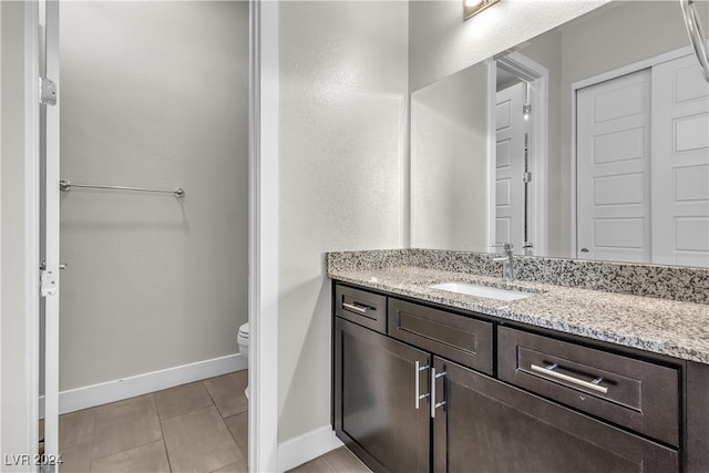 bathroom featuring tile patterned flooring, vanity, and toilet