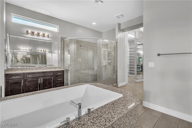 bathroom with tile patterned flooring, vanity, and plus walk in shower