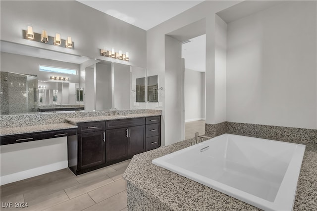 bathroom featuring vanity and tiled tub