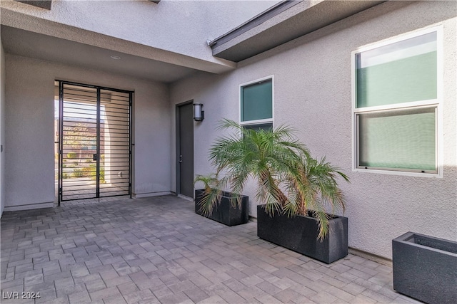 view of exterior entry with a patio