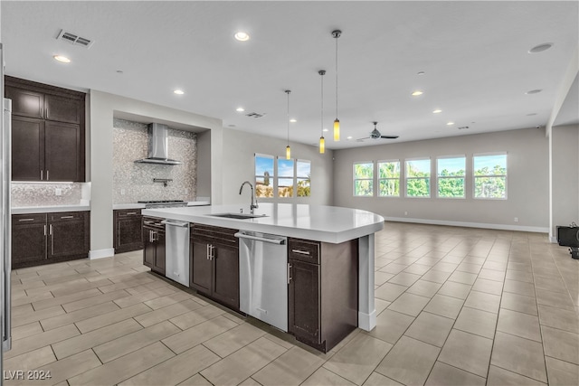 kitchen with dishwasher, a center island with sink, wall chimney range hood, sink, and tasteful backsplash