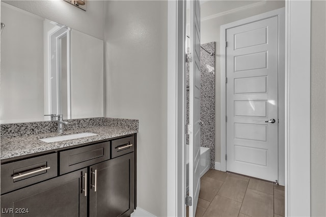 bathroom featuring tile patterned flooring, vanity, and tiled shower / bath combo