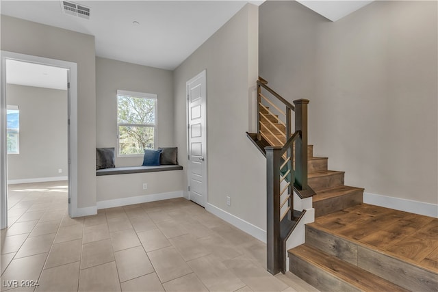 stairs featuring plenty of natural light and tile patterned flooring