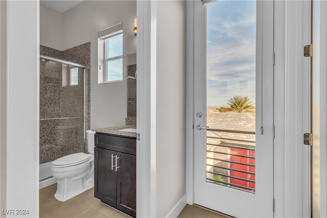 bathroom featuring vanity, toilet, and a shower with door