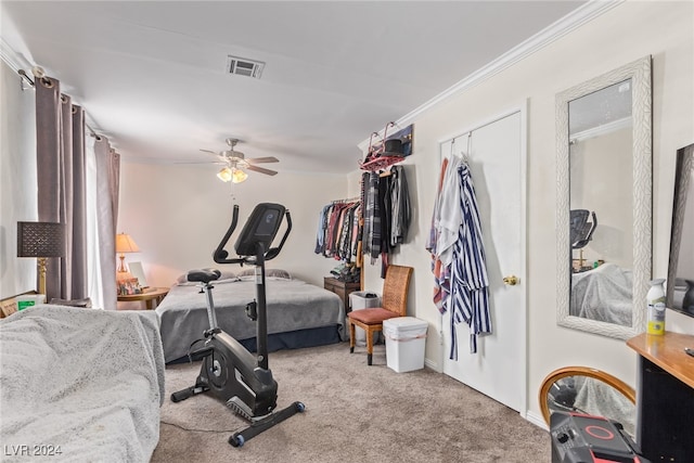 carpeted bedroom featuring ceiling fan and crown molding