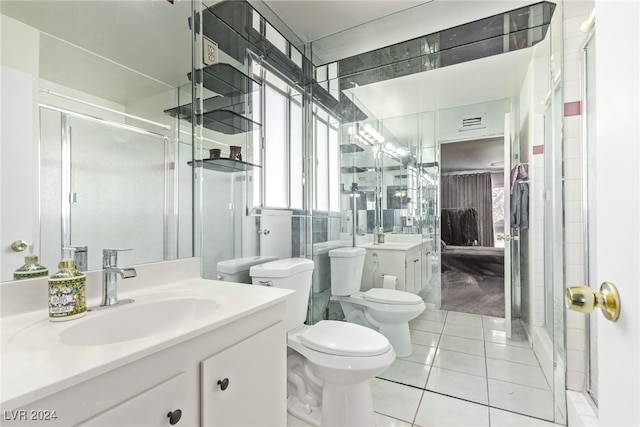 bathroom featuring toilet, vanity, tile patterned floors, and an enclosed shower