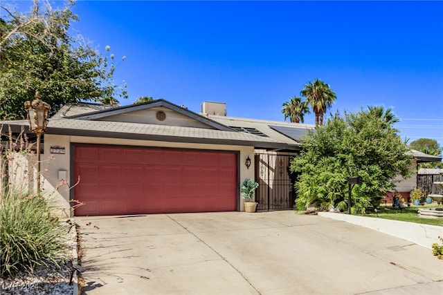 ranch-style home with solar panels and a garage