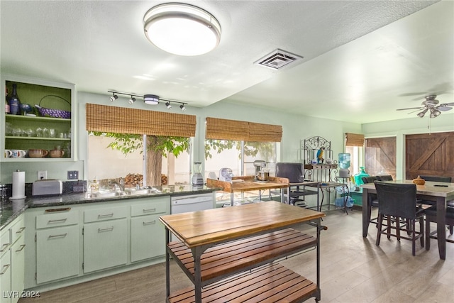 kitchen featuring a textured ceiling, ceiling fan, sink, dishwasher, and light hardwood / wood-style floors