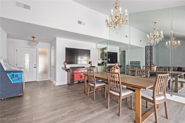 dining area with hardwood / wood-style floors and a towering ceiling