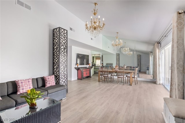 living room featuring light hardwood / wood-style flooring, a towering ceiling, and a chandelier