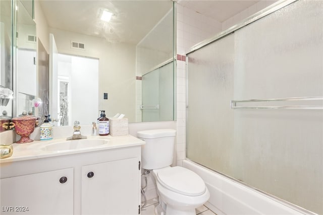 full bathroom featuring tile patterned flooring, vanity, enclosed tub / shower combo, and toilet