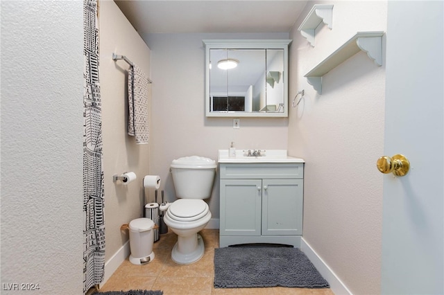 bathroom featuring tile patterned flooring, vanity, and toilet