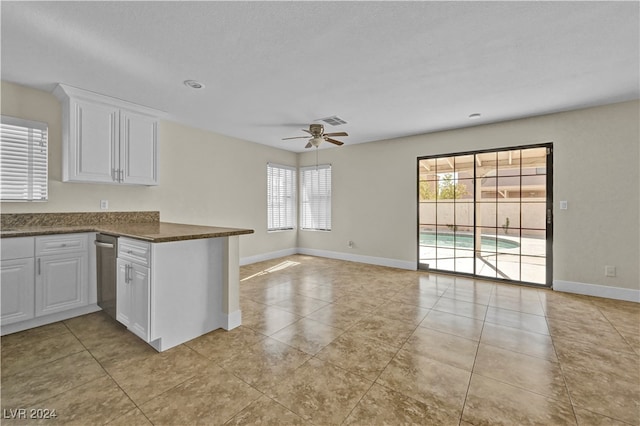 kitchen featuring kitchen peninsula, white cabinetry, ceiling fan, and light tile patterned flooring