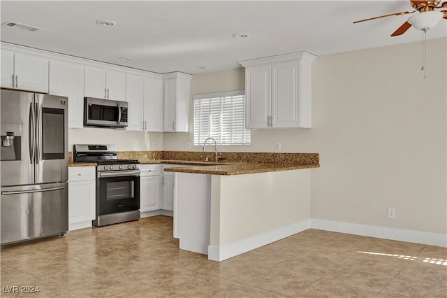 kitchen with ceiling fan, dark stone countertops, white cabinetry, kitchen peninsula, and stainless steel appliances