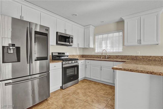 kitchen featuring light tile patterned flooring, sink, white cabinets, and stainless steel appliances