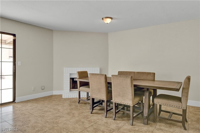 dining room featuring light tile patterned flooring and a fireplace