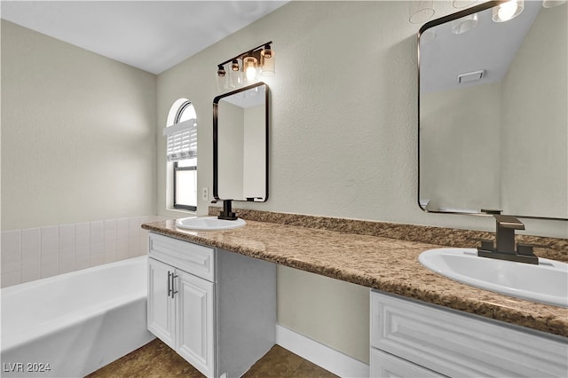 bathroom with a washtub, vanity, and tile patterned floors