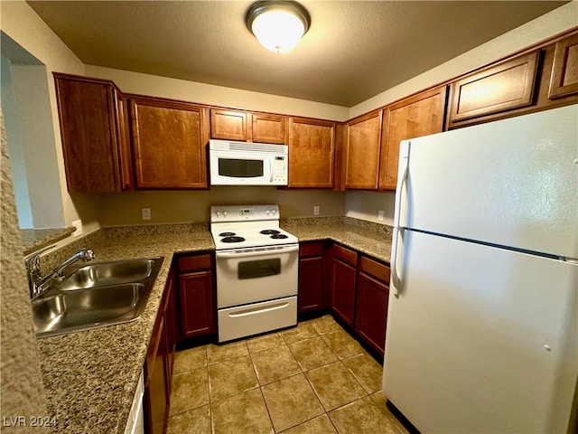 kitchen with stone counters, light tile patterned floors, white appliances, and sink