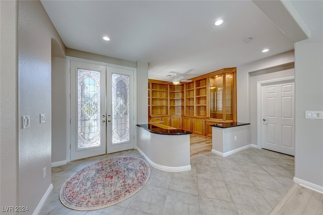 tiled entryway featuring ceiling fan and french doors