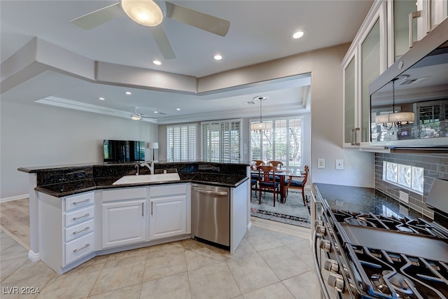 kitchen with dark stone counters, white cabinets, sink, decorative backsplash, and stainless steel appliances