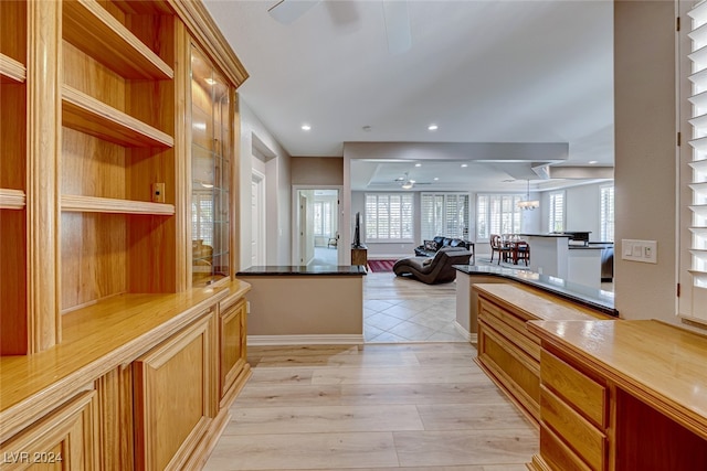 entryway with ceiling fan with notable chandelier and light wood-type flooring