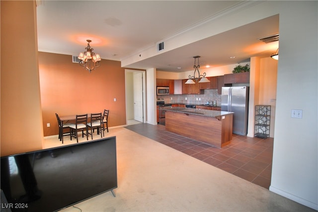 kitchen with backsplash, a kitchen bar, pendant lighting, and appliances with stainless steel finishes