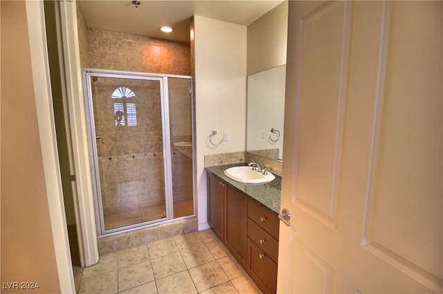 bathroom featuring tile patterned flooring, vanity, and an enclosed shower