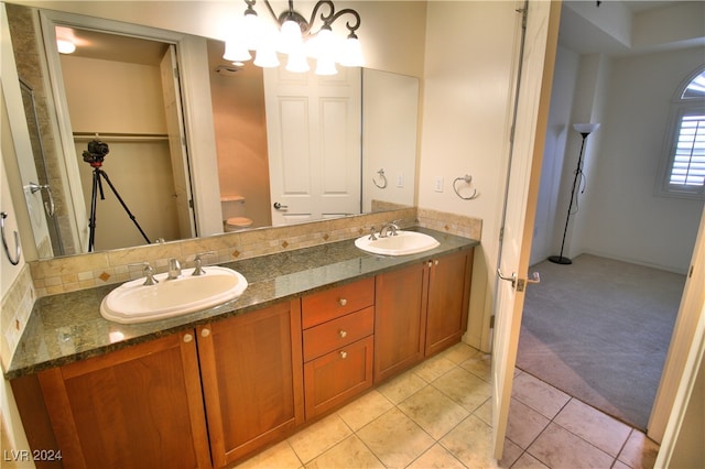 bathroom with tile patterned flooring, decorative backsplash, vanity, and toilet