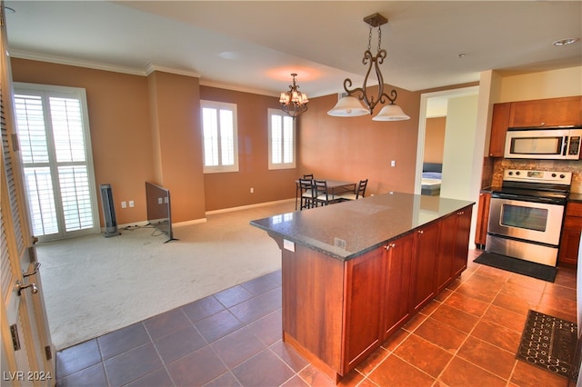 kitchen featuring dark colored carpet, a notable chandelier, pendant lighting, a kitchen island, and appliances with stainless steel finishes