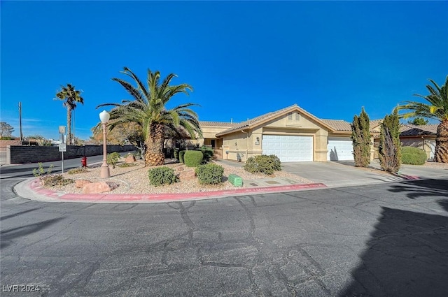 view of front of property with a tiled roof, stucco siding, concrete driveway, and a garage